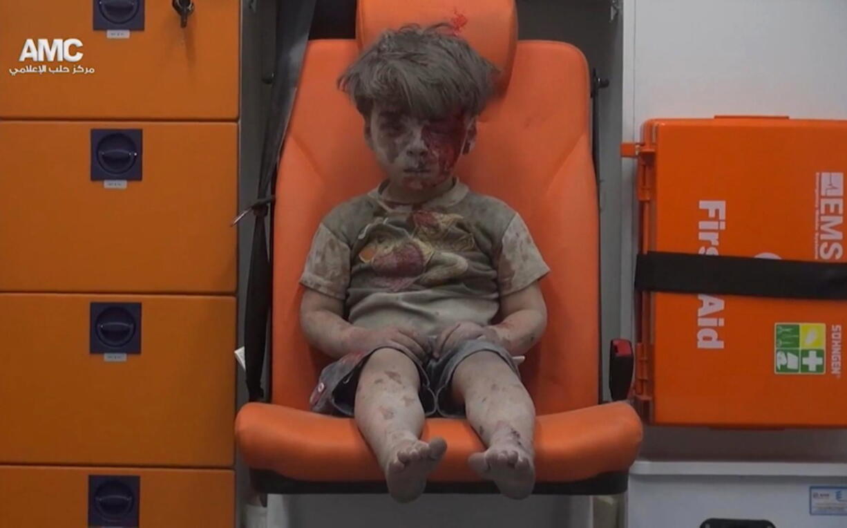 In this frame grab taken from video provided by the Syrian anti-government activist group Aleppo Media Center, a child sits in an ambulance after being pulled out or a building hit by an airstirke, in Aleppo, Syria, Wednesday, Aug. 17, 2016. Syrian opposition activists reported an airstrikes on the al-Qaterji neighborhood in Aleppo late Wednesday.