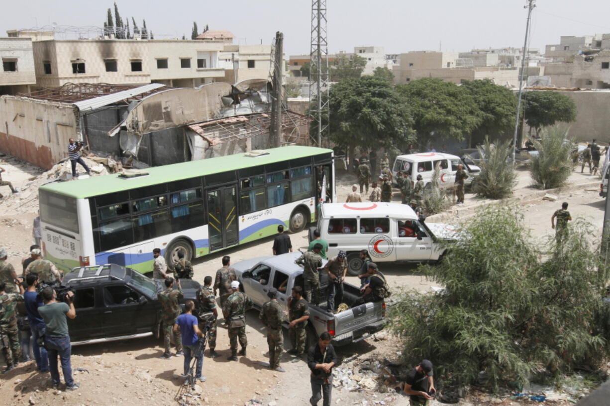 Syrian government buses and a number of the Syrian Arab Red Crescent ambulances at the entrance of Daraya, a suburb of Damascus, Syria on Friday. The development in the Daraya suburb is part of an agreement struck between the rebels and the government of President Bashar Assad. Rebels in Daraya agreed to evacuate after four years of grueling bombardment and a crippling siege that has left the sprawling suburb southwest of the capital in ruins.