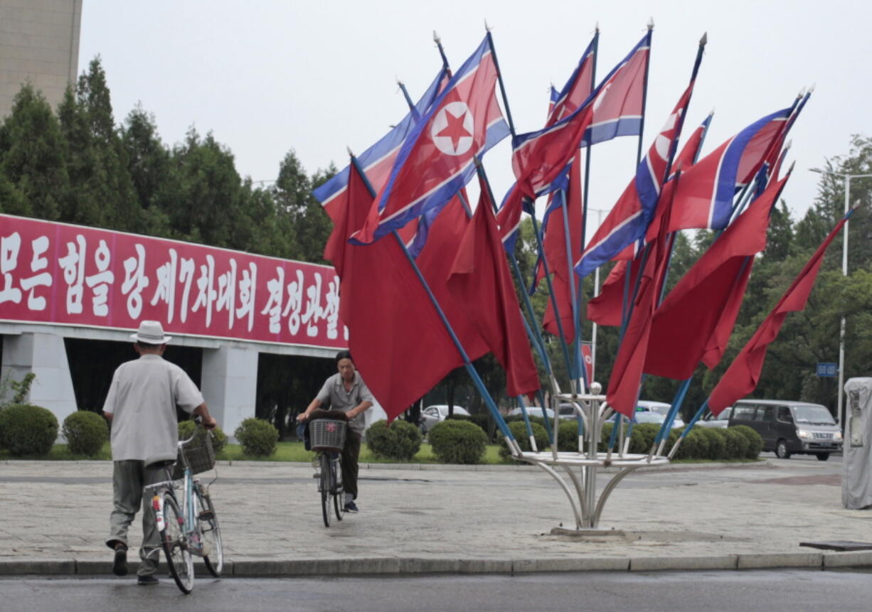 A North Korean rides a bicycle past national flags flown to mark the celebration of Songun Day or the &quot;Military First&quot; holiday Thursday in Pyongyang, North Korea.