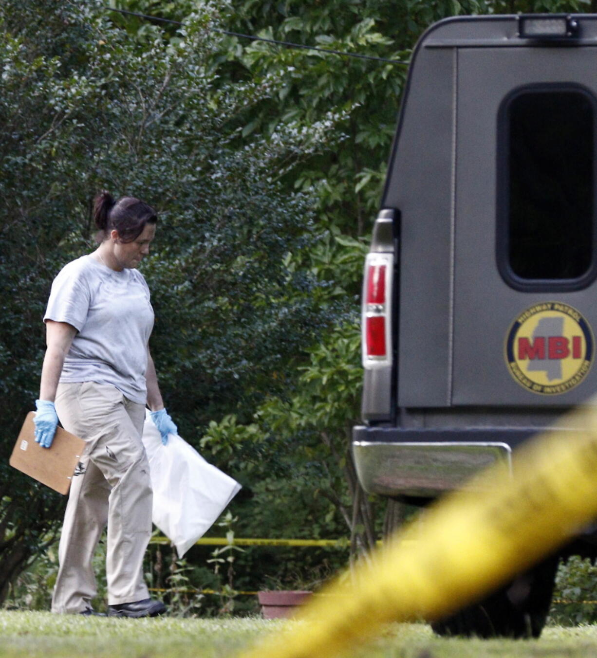 A Mississippi Bureau of Investigation agent takes a bag with evidence from the Durant, Miss., home of two slain Catholic nuns who worked as nurses at the Lexington Medical Clinic, to her vehicle, Thursday. (AP Photo/Rogelio V.