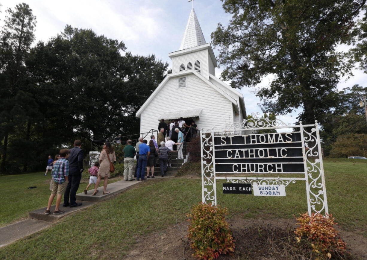 People stand in line to attend a vigil for the deceased held at St. Thomas Catholic Church in Lexington, Miss., for Sister Margaret Held and Sister Paula Merrill on Sunday. The two nuns, from different orders, were found murdered in the Durant, Miss., house they rented, on Thursday. Over 300 people attended the service. Although authorities have arrested a suspect, they speculate on the motive of the deaths of the two nurse practitioners, who worked the poor in a clinic in Lexington. (AP Photo/Rogelio V.