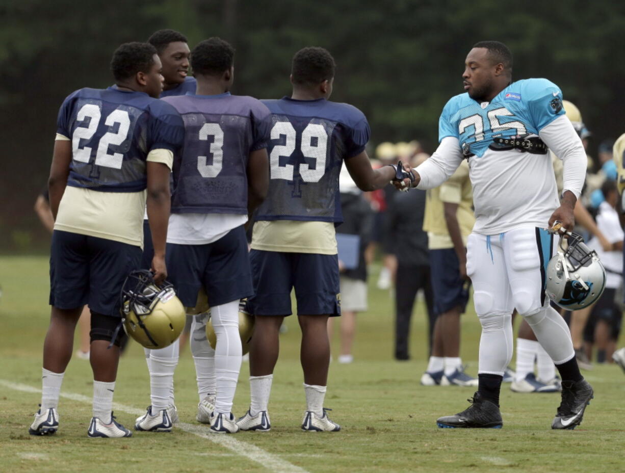 Carolina Panthers&#039; Mike Tolbert, right, greets members of the Spartanburg High School football team during a joint practice session on Thursday.