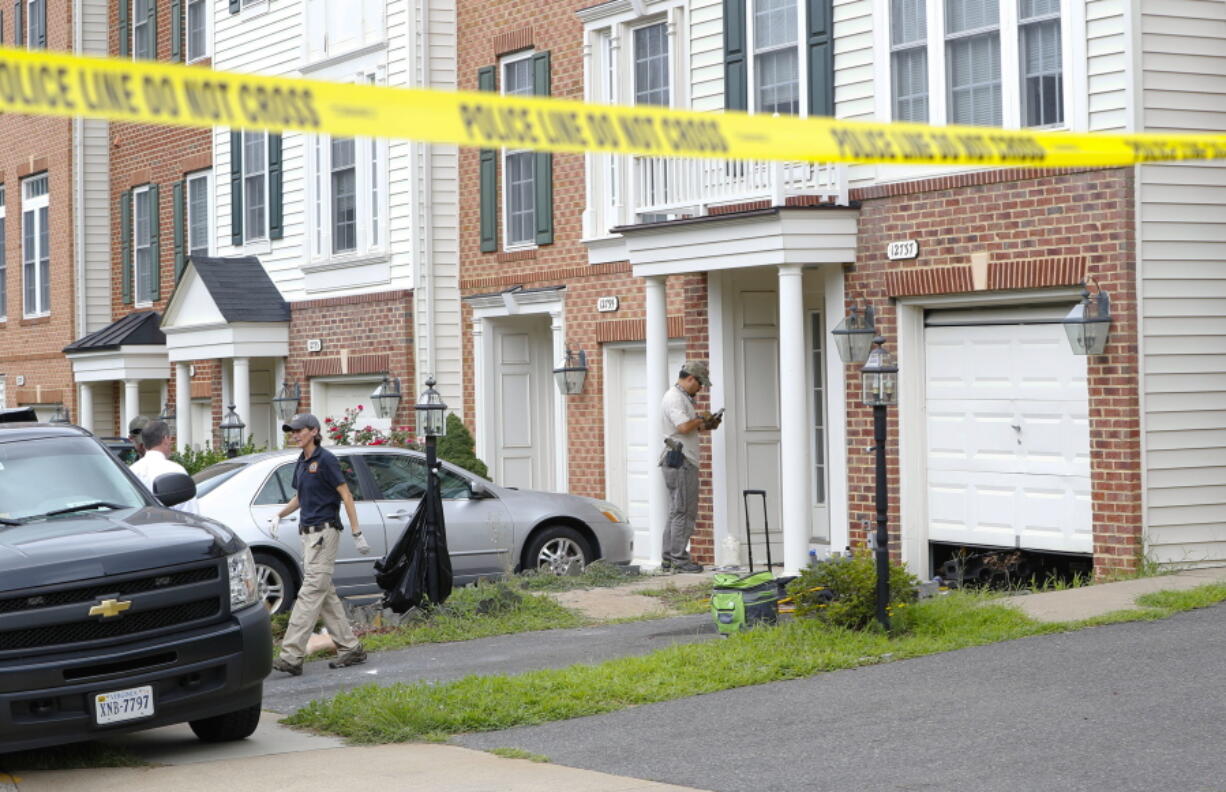 Law enforcement officers are seen outside the home of Nicholas Young, a Washington Metro Transit Officer on  Wednesday in Fairfax, Va., Young was arrested at Metro&#039;s headquarters in Washington and charged with a single count of attempting to provided material support to a terrorist group.