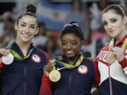 Bronze medallist Russia's Aliya Mustafina, right, gold medallist United States' Simone Biles, center, and silver medallist United States' Aly Raisman display their medals for the artistic gymnastics women's individual all-around final at the 2016 Summer Olympics in Rio de Janeiro, Brazil, Thursday, Aug. 11, 2016.