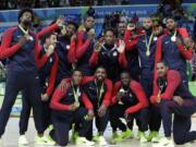 The United States' team pose with their gold medals for men's basketball at the 2016 Summer Olympics in Rio de Janeiro, Brazil, Sunday, Aug. 21, 2016.