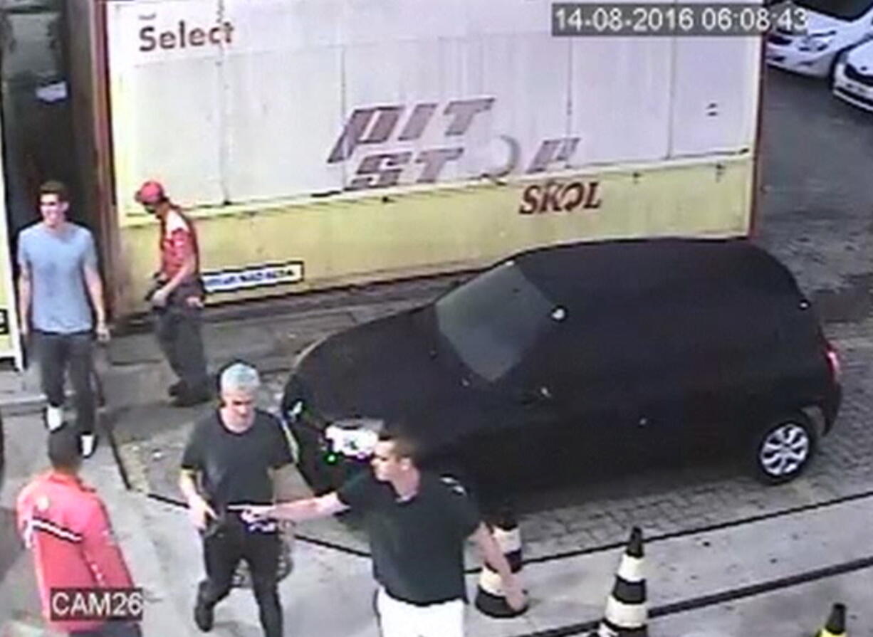 In this frame from surveillance video released by Brazil Police, swimmer Ryan Lochte, second from right, nd teammates appear at a ga station during the 2016 Summer Olympics in 
 +Rio de Janeiro, Brazil. A top Brazil police official said the swimmers damaged property at the gas station. (Brazil Police via AP)