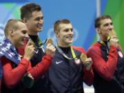 The United States team from left, Caeleb Dressel, Nathan Adrian, Ryan Held and Michael Phelps celebrate after winning the gold medal in the men's 4x100-meter freestyle relay during the swimming competitions at the 2016 Summer Olympics, Monday, Aug. 8, 2016, in Rio de Janeiro, Brazil.