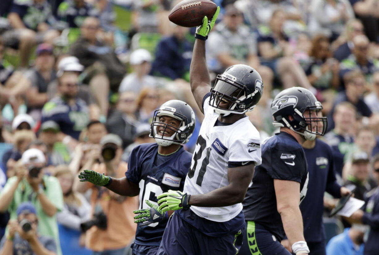 Seattle Seahawks&#039; Kam Chancellor (31) raises the ball after intercepting a pass during a scrimmage at the team&#039;s training camp Saturday.