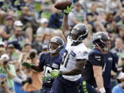 Seattle Seahawks&#039; Kam Chancellor (31) raises the ball after intercepting a pass during a scrimmage at the team&#039;s training camp Saturday.