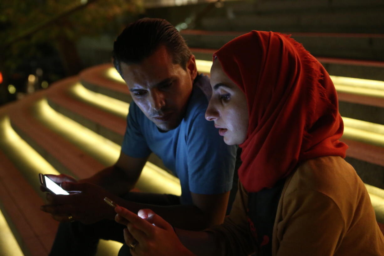 Bahr Abdul Razzak, 29, left, and his wife, Noura Al-Ameer, 29, hold their phones in Istanbul, on Monday.