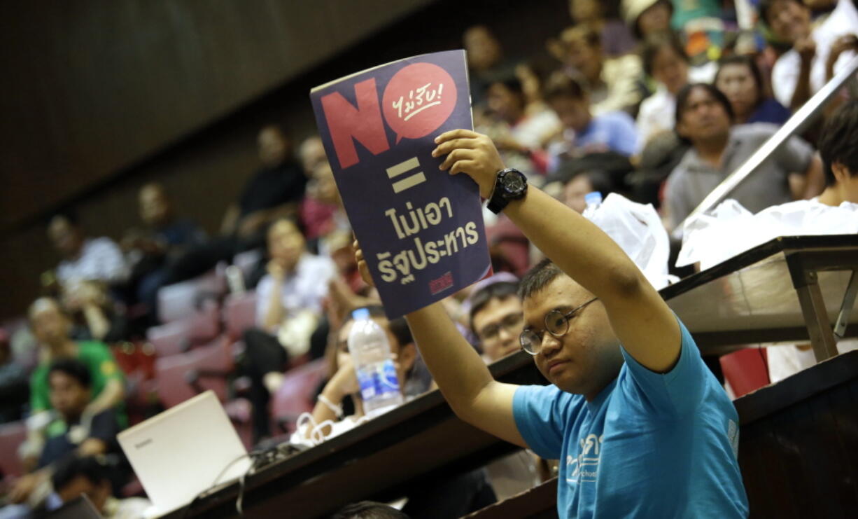 A Thai student Sunday holds a poster reading &quot;vote no = no coup&quot; at Thammasat University in Bangkok, Thailand. Thai voters on Sunday overwhelmingly approved a new junta-backed constitution that lays the foundation for a civilian government influenced by the military and controlled by appointed -- rather than elected -- officials.