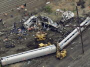 Emergency personnel work at the scene of a derailment in Philadelphia of an Amtrak train headed to New York on May 13, 2015.  Many commuter and freight railroads have made little progress installing safety technology designed to prevent deadly collisions and derailments despite a mandate from Congress, according to a government report released Wednesday, Aug. 17, 2016.