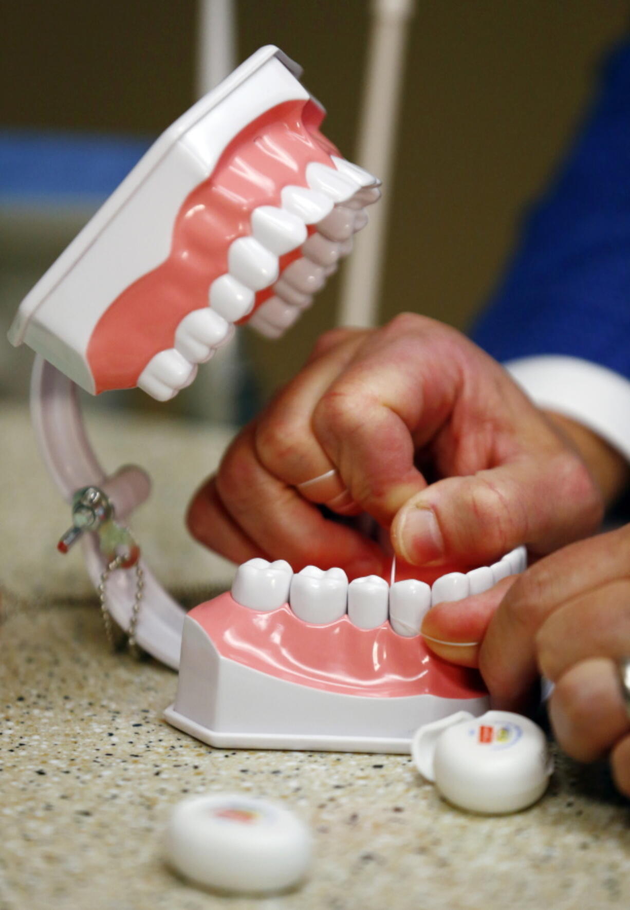 Dr. Wayne Aldredge, president of the American Academy of Periodontology, demonstrates how dental floss should be used in Holmdel, N.J. Aldredge says many people use floss incorrectly, moving it in a sawing motion instead of up and down the sides of the teeth.