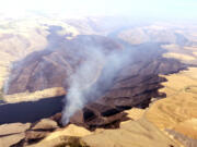 The Snake River Complex Fire continues to burn on both sides of the river west of Colton, Wash., on Wednesday, Aug. 3, 2016. The state of Washington is managing firefighters and aircraft that are fighting the 10,000 fire, which was 10-percent contained as of Wednesday evening. Three college-age men admitted to the Whitman County Sheriff's Office on Wednesday that they lit a campfire near the are where the fire started. The fire started in Garfield County and the jumped the Snake River into Whitman County.