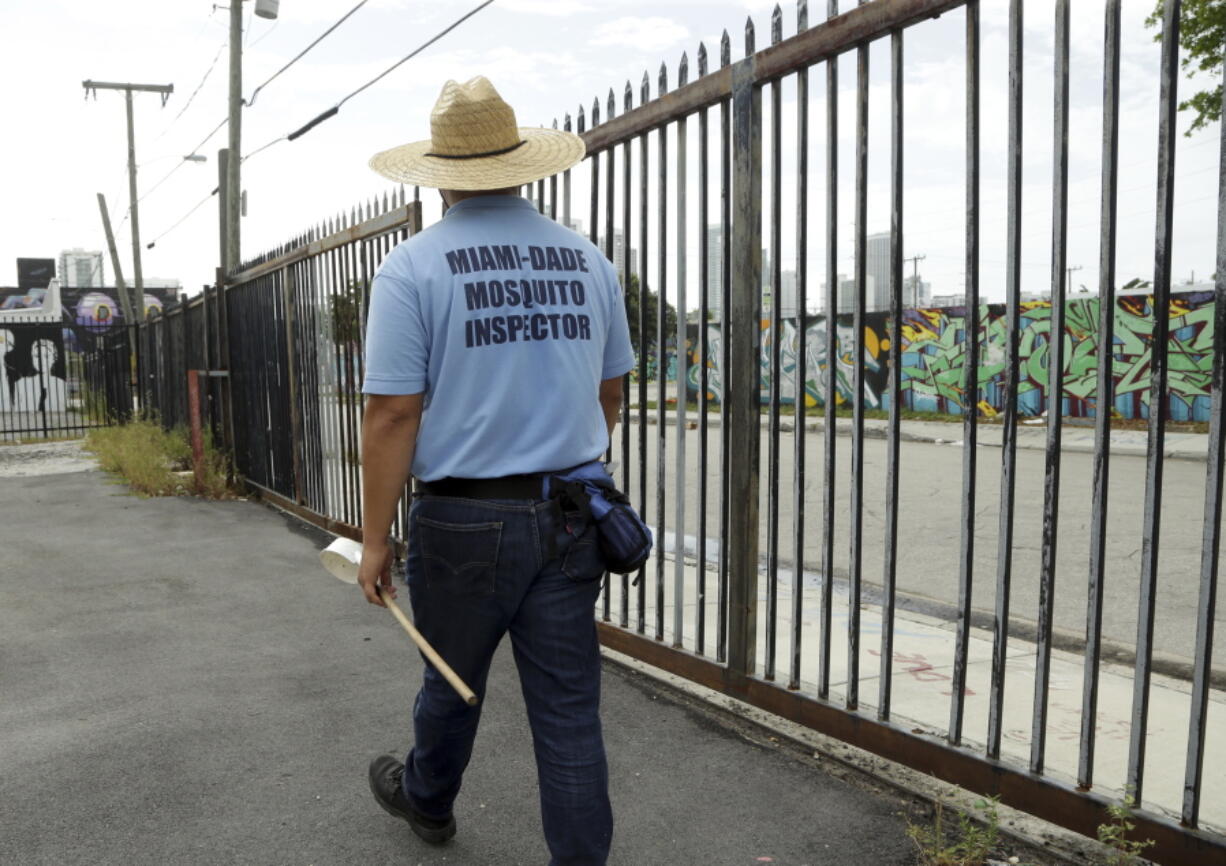 An inspector with the Miami-Dade County mosquito control department, looks for standing water as he inspects an empty lot Tuesday in the Wynwood neighborhood of Miami. The CDC has advised pregnant women to avoid travel to this neighborhood where mosquitoes are apparently transmitting Zika directly to humans.