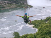 A tourist suspended above the water from zip lines makes his way at speeds of up to 40 mph toward the mist of the Horseshoe Falls, on the Ontario side of Niagara Falls. The overhead cables have evolved from a fun way to explore jungle canopies to trendy additions for long-established outdoor destinations.