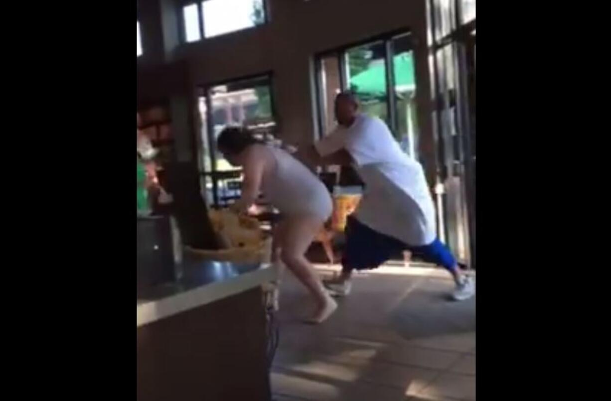 Two men fight on Tuesday morning in the Starbucks in Vancouver's Uptown Village neighborhood, as seen in a frame of a video shot by bystanders. The police said the man in his underwear fled to the coffee shop after the attacker broke into his nearby apartment.