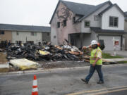 Matthew Zugajewicz of Northwest Traffic Control prepares to set up cones to route traffic around the scene of a fire at a construction site Thursday morning. The fire was reported at about 1:30 a.m. in the 5700 block of Northeast 47th Street.