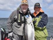 Oregon angler Randy Woosley, left, holds a nice chinook he landed at Buoy 10 with guide Bill Monroe Jr.