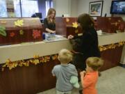 Riverview Community Bank teller Brenda Wilson helps customers at the downtown Vancouver Riverview location Thursday.