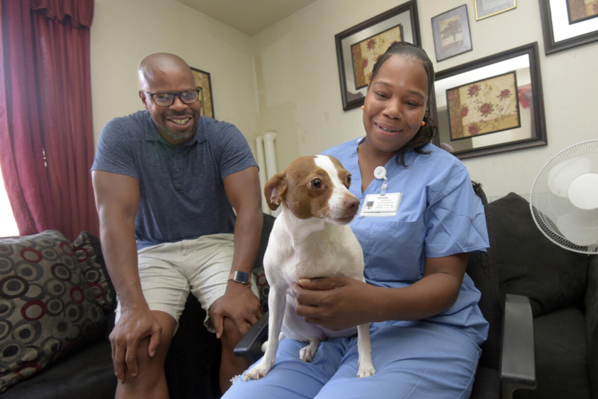 James Evans, CEO of illume, sits with Juanita Stern in her home with her terrier, Pup-Pup. Juanita had her dog and cats spayed and neutered by Charm City Companions, who also operated on Pup-Pup without charge when he was sick. Charm City Companions is a nonprofit supported by illume.