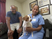 James Evans, CEO of illume, sits with Juanita Stern in her home with her terrier, Pup-Pup. Juanita had her dog and cats spayed and neutered by Charm City Companions, who also operated on Pup-Pup without charge when he was sick. Charm City Companions is a nonprofit supported by illume.