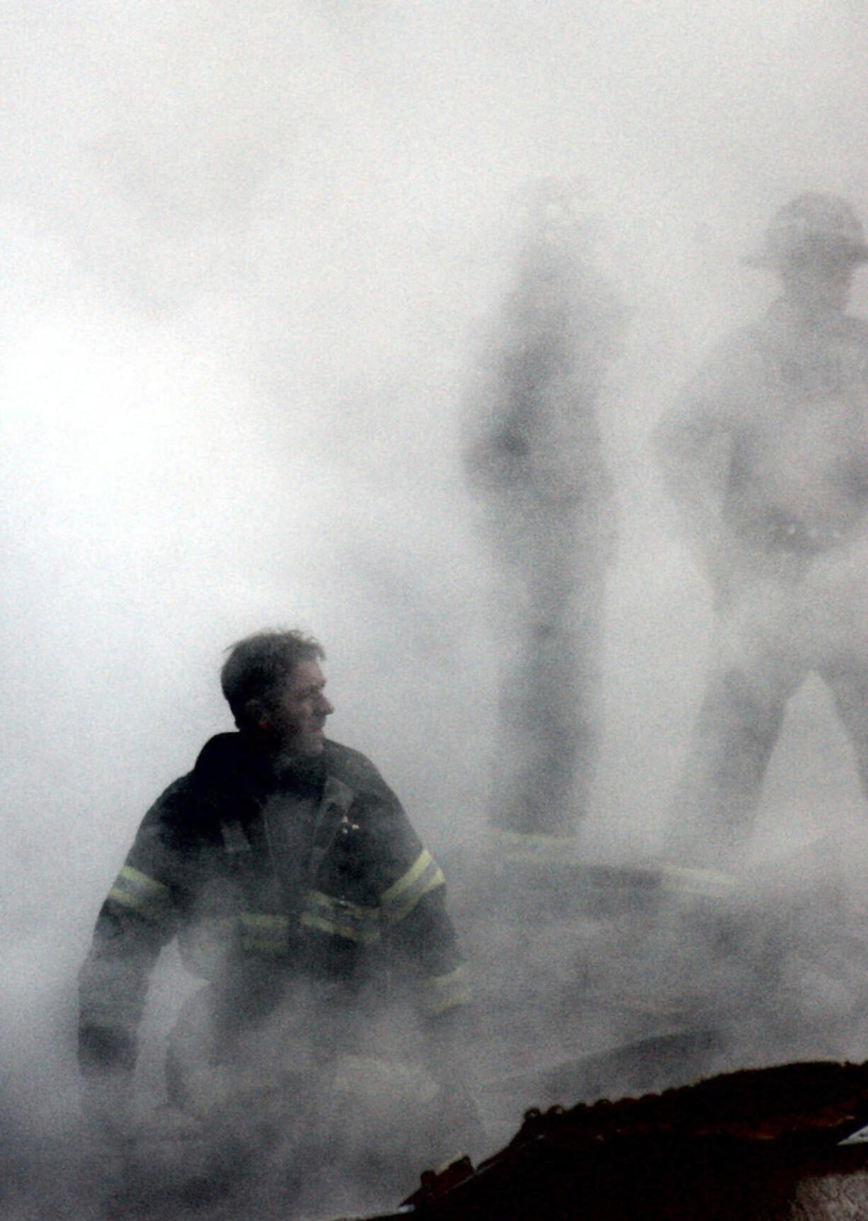 A firefighter emerges from the smoke and dust at the World Trade Center on Sept. 14, 2001.