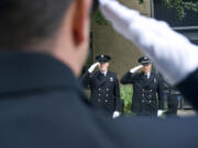 Captain Tyler Dillmon, left, and Marc Patchin, are framed by fellow Vancouver fireman Joe Hudson in salute during the Patriot Day ceremony at Vancouver City Hall on Sunday, Sept. 11, 2016. The ceremony was held in remembrance of the nearly 3,000 people who died in the terrorist attacks on September 11, 2001.