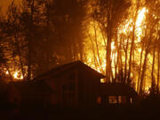 The Okanogan Complex Fire burns behind a home in Twisp on Aug. 20, 2015.