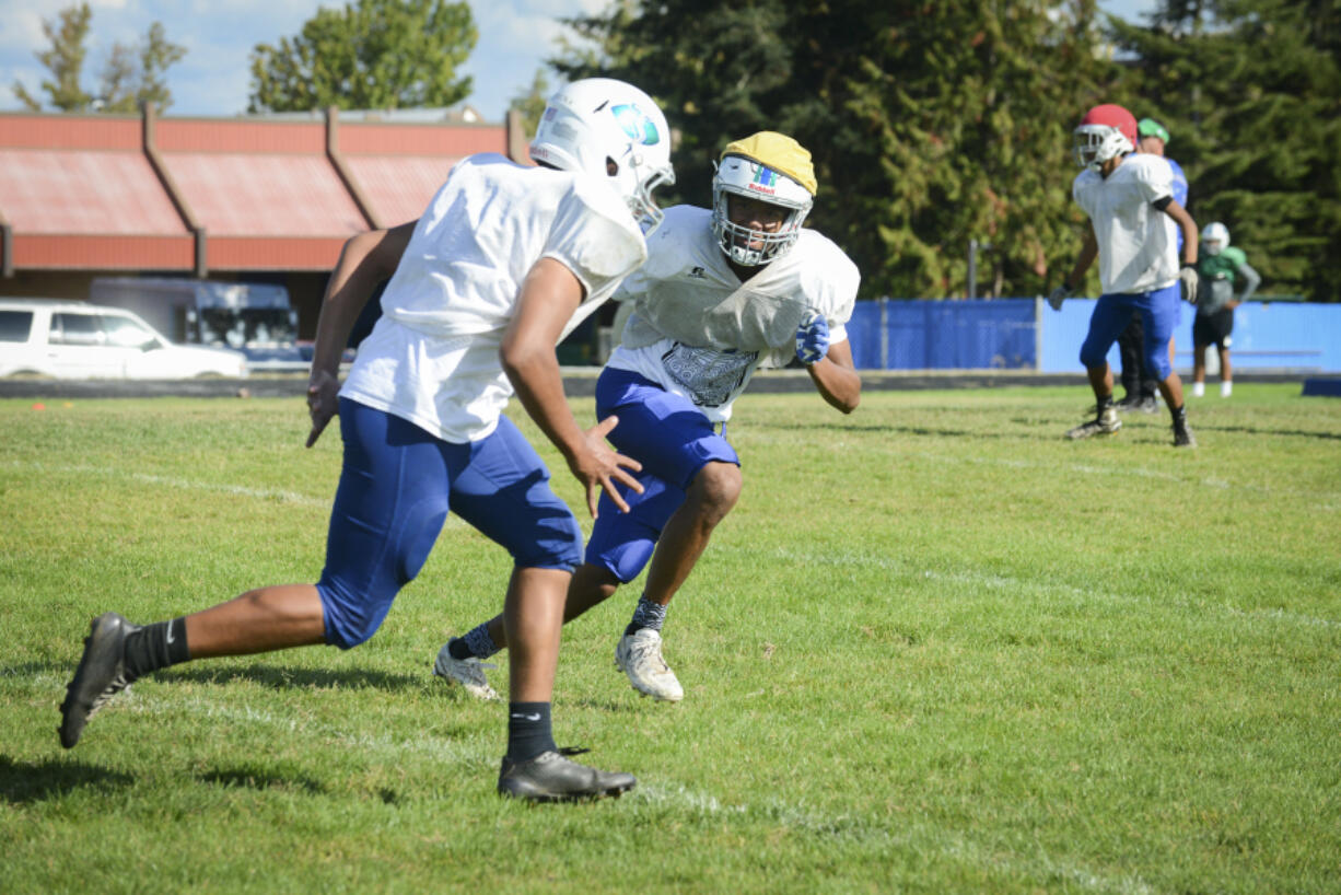 Sophomore wide receiver and defensive back Darien Chase, right, runs through a play with his teammates at Mountain View High School.