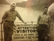 Arnold Soukup, left, and a shipmate next to a sign reminding visitors not to smoke on a Navy ammunition ship. (U.S.