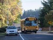 A school bus drives past parked cars along Northeast 81st Avenue on Sept. 28. Some residents say the lack of sidewalks is a danger for students of Peter S. Ogden Elementary school at the end of the street.