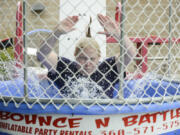 Jenny Thompson, the executive director for the Vancouver Police Activities League, falls into the dunk tank Thursday at Mill Creek Pub during Give More 24!