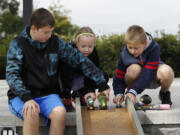 Sam Vernon, 12, from left, Mary Vernon, 7, and Jack Vernon, 10, of Vancouver, have their veggie racers ready to roll Saturday at Overlook Park in Ridgefield.