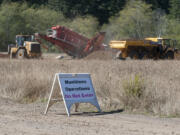 A sign warns visitors of danger as workers with Weston Solutions Inc. sift through the remainder of the spoils from the small arms range Friday afternoon at Camp Bonneville. The U.S.