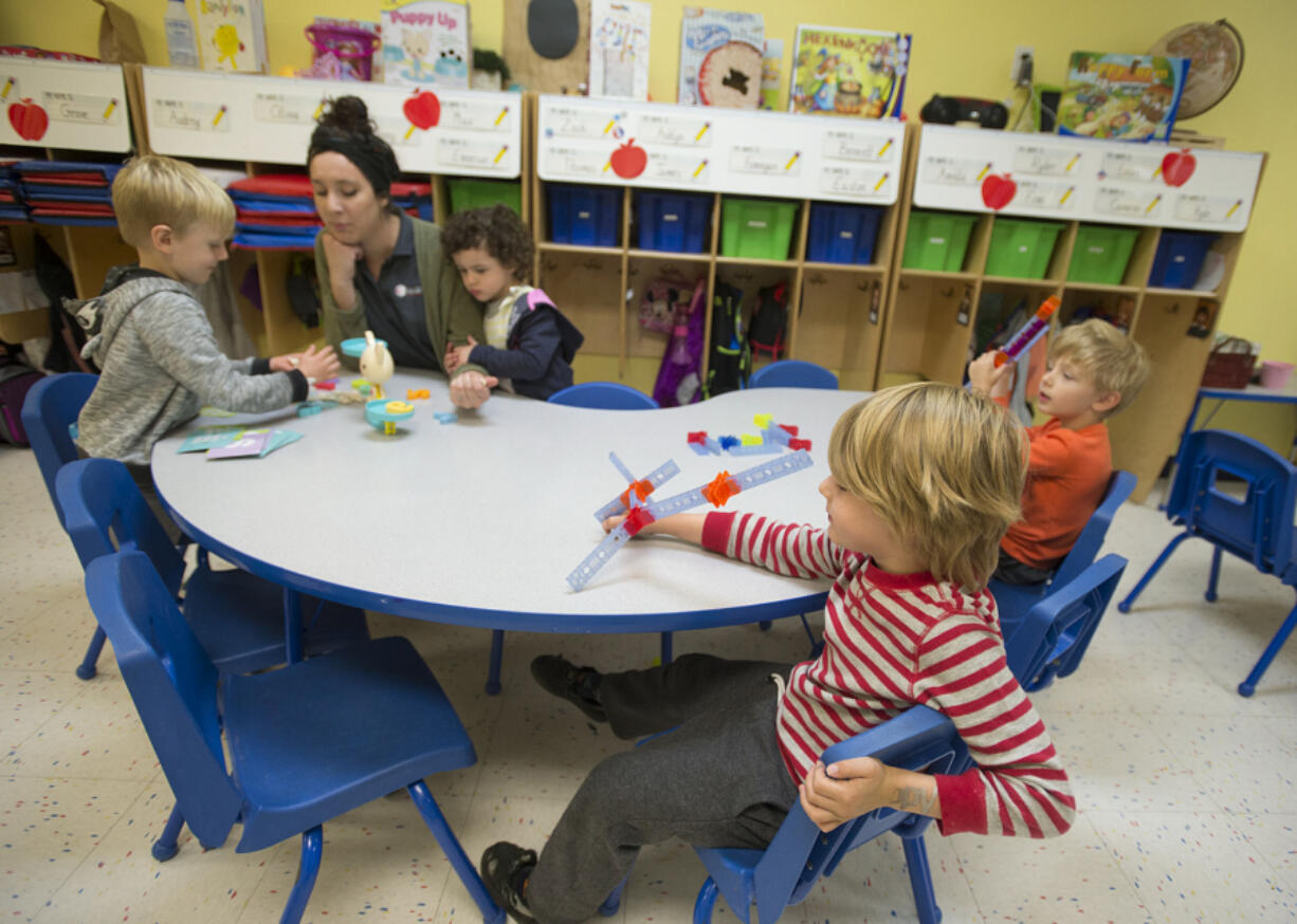 Finn Stone-Krause, from left, plays Puppy Up with teacher Elizabeth Blanchette and classmate Emerson Doepken as Zack Hunter and Lucas Ulmer play with Brackitz at The Goddard School on Thursday morning in Vancouver. All of the children are 4 years old.