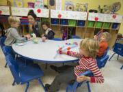 Finn Stone-Krause, from left, plays Puppy Up with teacher Elizabeth Blanchette and classmate Emerson Doepken as Zack Hunter and Lucas Ulmer play with Brackitz at The Goddard School on Thursday morning in Vancouver. All of the children are 4 years old.