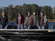 Baton Rouge police Officer Taylor Giroir, from left, Clark County sheriff's Deputy Jared Stevens, Battle Ground police Officer Slav Pavlenko and Baton Rouge police Cpl. Britt Jones celebrate their catch Monday morning. The group was one of a dozen that took to the Columbia River as part of a law enforcement appreciation event.