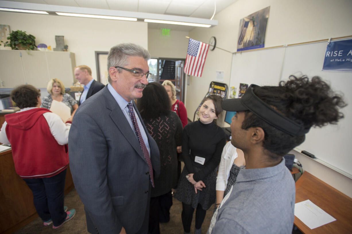 Gilliland chats with junior Samantha Raney, 16, and senior Nikesh Prasad, 17, at Henrietta Lacks Health and Bioscience High School on Monday morning.