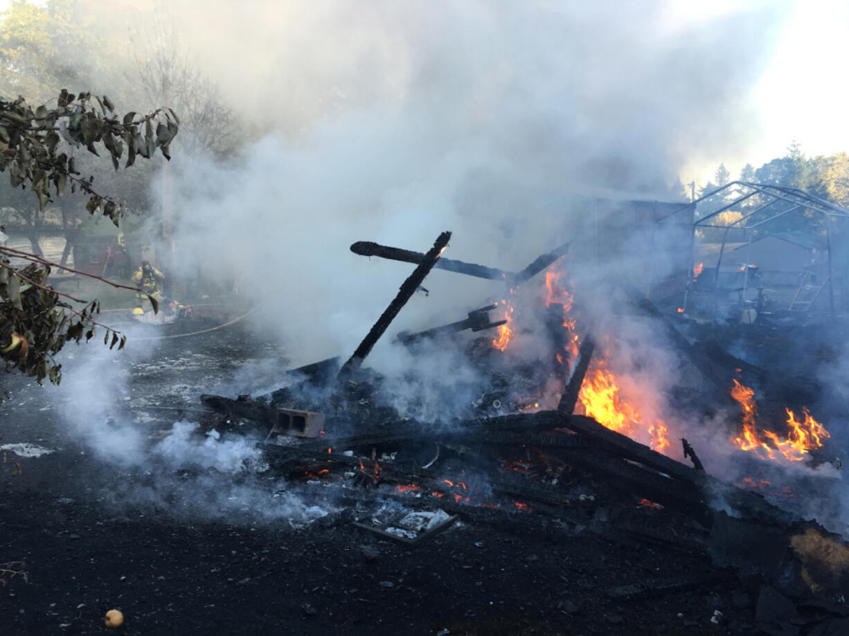 Firefighters extinguished a blaze that destroyed a shed and threatened a home near La Center on Monday.