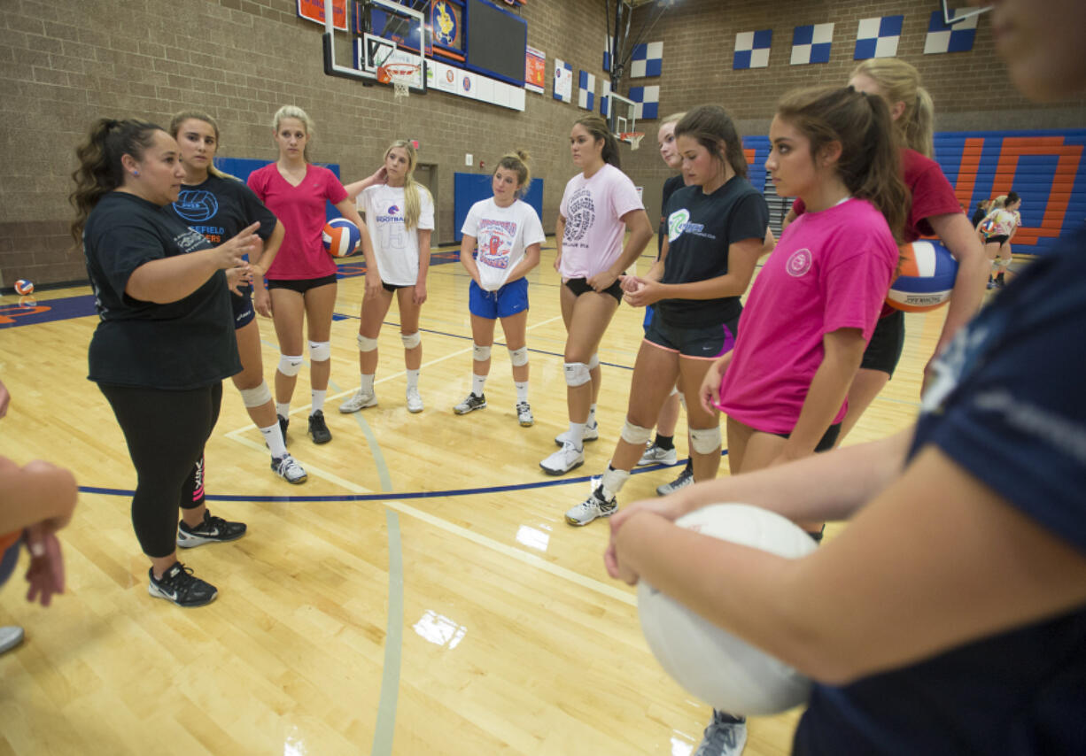 Ridgefield coach Sabrina Dobbs, left, works hard to keep her team's energy up during matches so that they play their best.