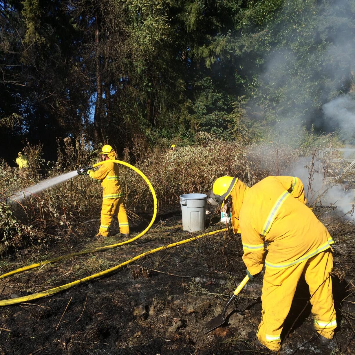 Firefighters respond to a small fire Wednesday afternoon in Brush Prairie that briefly threatened a home.