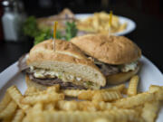 A Philly cheesesteak sandwich is served with fries Sept. 1 at Orchards Tap.