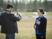 Erick Romero, left, takes a photo of his wife, Lorena Topete, a native of Mexico, outside Pearson Air Museum in Vancouver on Wednesday following a naturalization ceremony for 21 new American citizens.