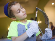 Sroli Greenberg, 5, gives his shofar a good shellacking during a Shofar Factory Holiday Workshop at the Chabad Jewish Center in Clark County on Sunday. Children were given the opportunity to finish a shofar, a ram&#039;s horn blown during the Rosh Hashanah, which begins Oct. 2 at sundown.