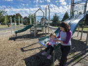 Dallas Cunningham, who will be 2 on Tuesday, explores the playground equipment at Diamond Park in Orchards with her mom, Dae. The two try to walk every day, and the planned improvement of a path through Diamond Park is something they are looking forward to.