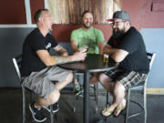 From left, Tom Poffenroth and Devon Bray, co-owners of Loowit Brewing Company, enjoy a beer with Michael Perozzo, founder of ZZoom Media, at Loowit in downtown Vancouver. They&#039;re among the organizers of North Bank Beer Week, which begins Thursday.