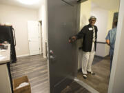 Resident Karl Colbert holds the door open for visitors Wednesday morning while showing off his new apartment at Freedom&#039;s Path.