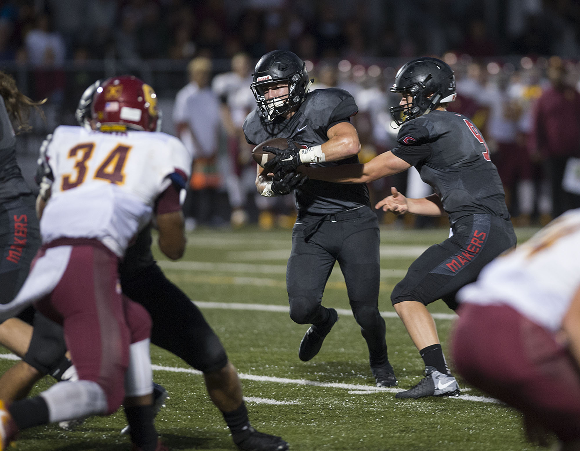 Camas' Michael Matthews, center, gets a handoff from teammate Jack Colletto (9) while on his way to scoring a touchdown in the second quarter Friday night, Sept. 2, 2016 at Doc Harris Stadium.