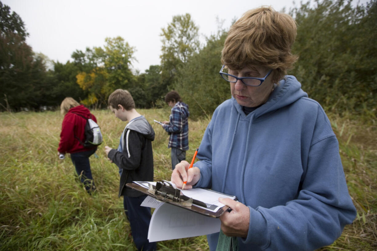 Volunteer Jane Skelly writes down data at the Eco-Blitz at Vancouver Lake. Volunteers recording wildlife in and around the lake.